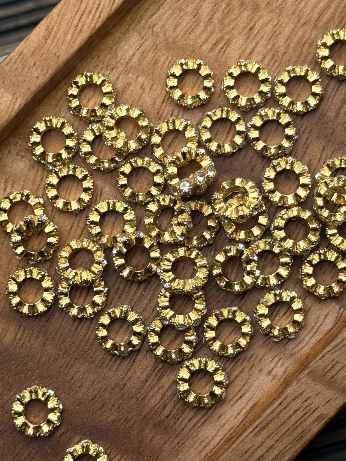Gold 10mm metal rhinestone spacer beads with brilliant clear rhinestones and decorative texture. Ideal for beadable pens, jewelry, and craft projects. Sold in 20-count bags.