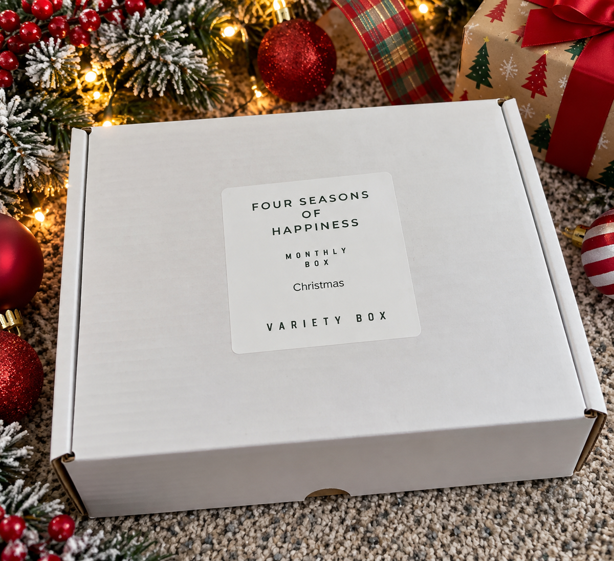 Four Seasons of Happiness Christmas variety craft box featuring holiday beads and beadable supplies in festive red, green, and white colors, packaged in a white gift box surrounded by Christmas decorations.