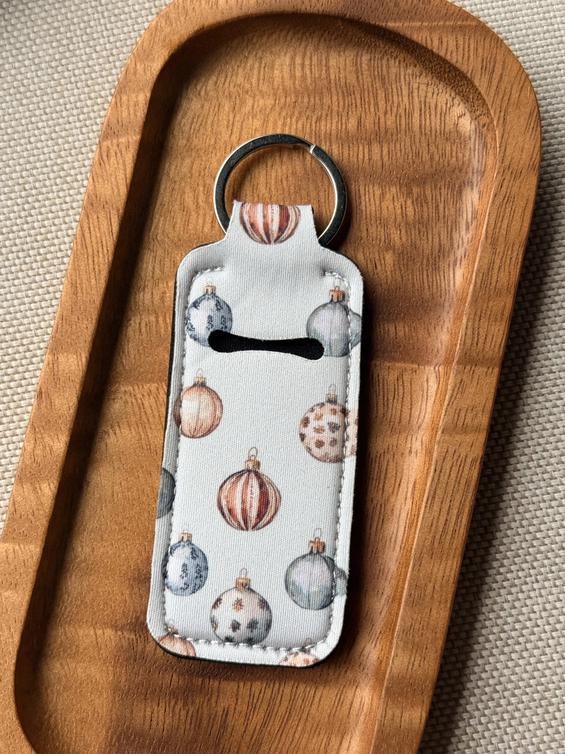 Soft neoprene chapstick holder keychain by Four Seasons of Happiness featuring assorted floral, Christmas, winter, holiday and seasonal printed designs with a durable metal keyring.