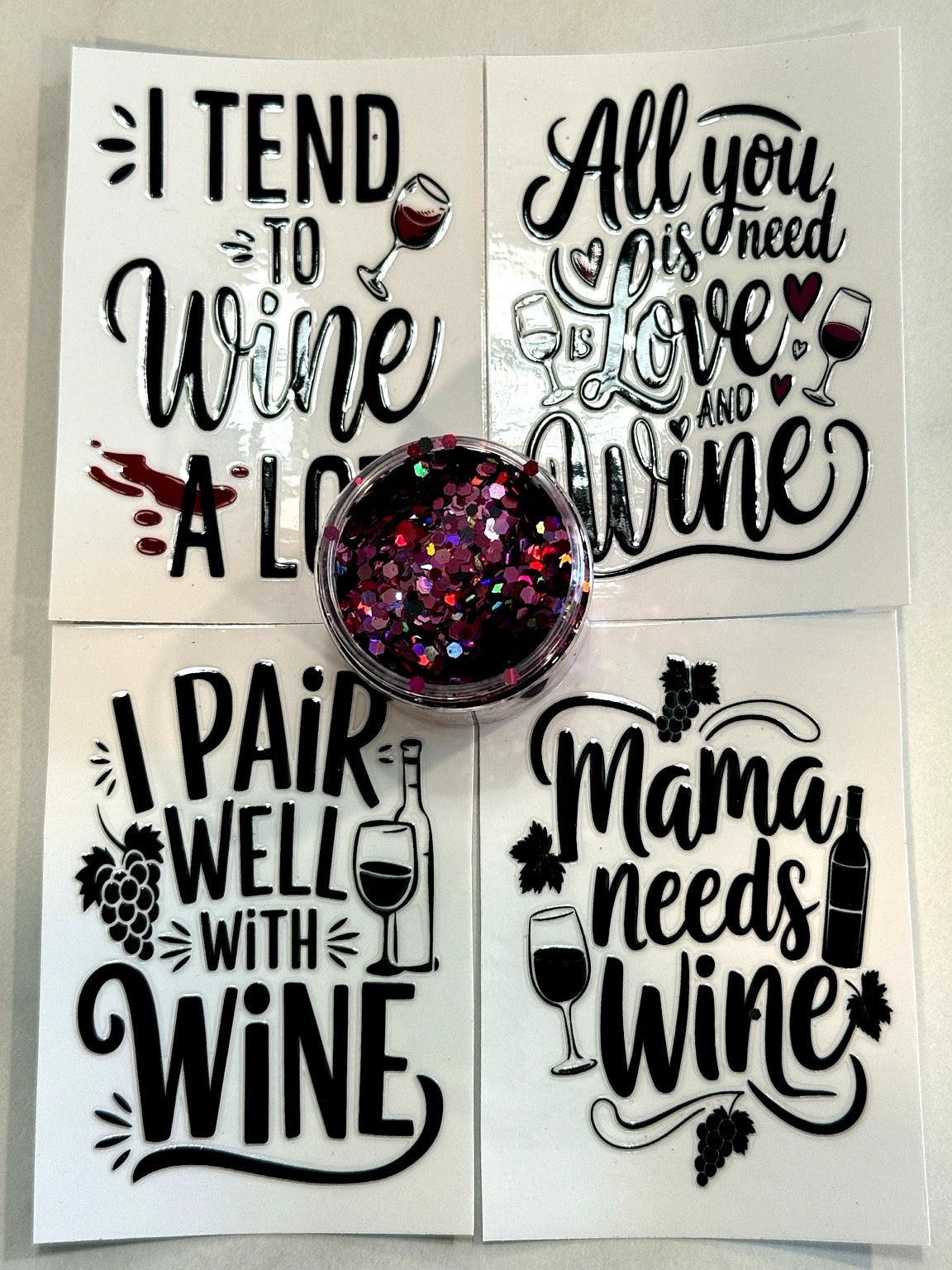 Wine themed UVDTF cup wraps with glitter for DIY snow globe tumblers and drinkware crafting from Four Seasons of Happiness.