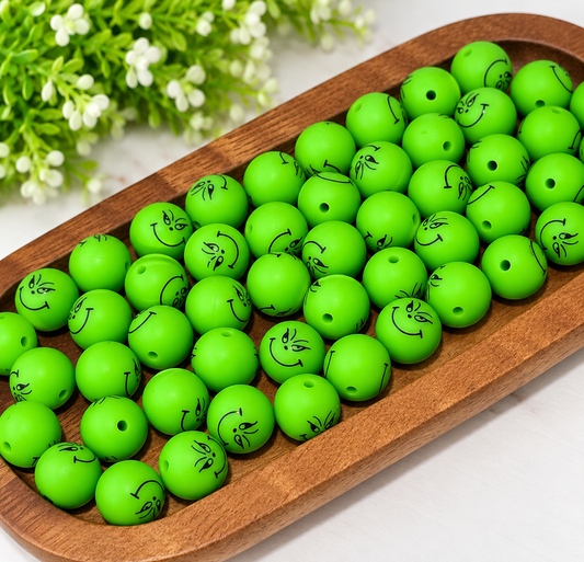 Neon green 15mm printed silicone round beads featuring black mischievous smiling faces, sold individually