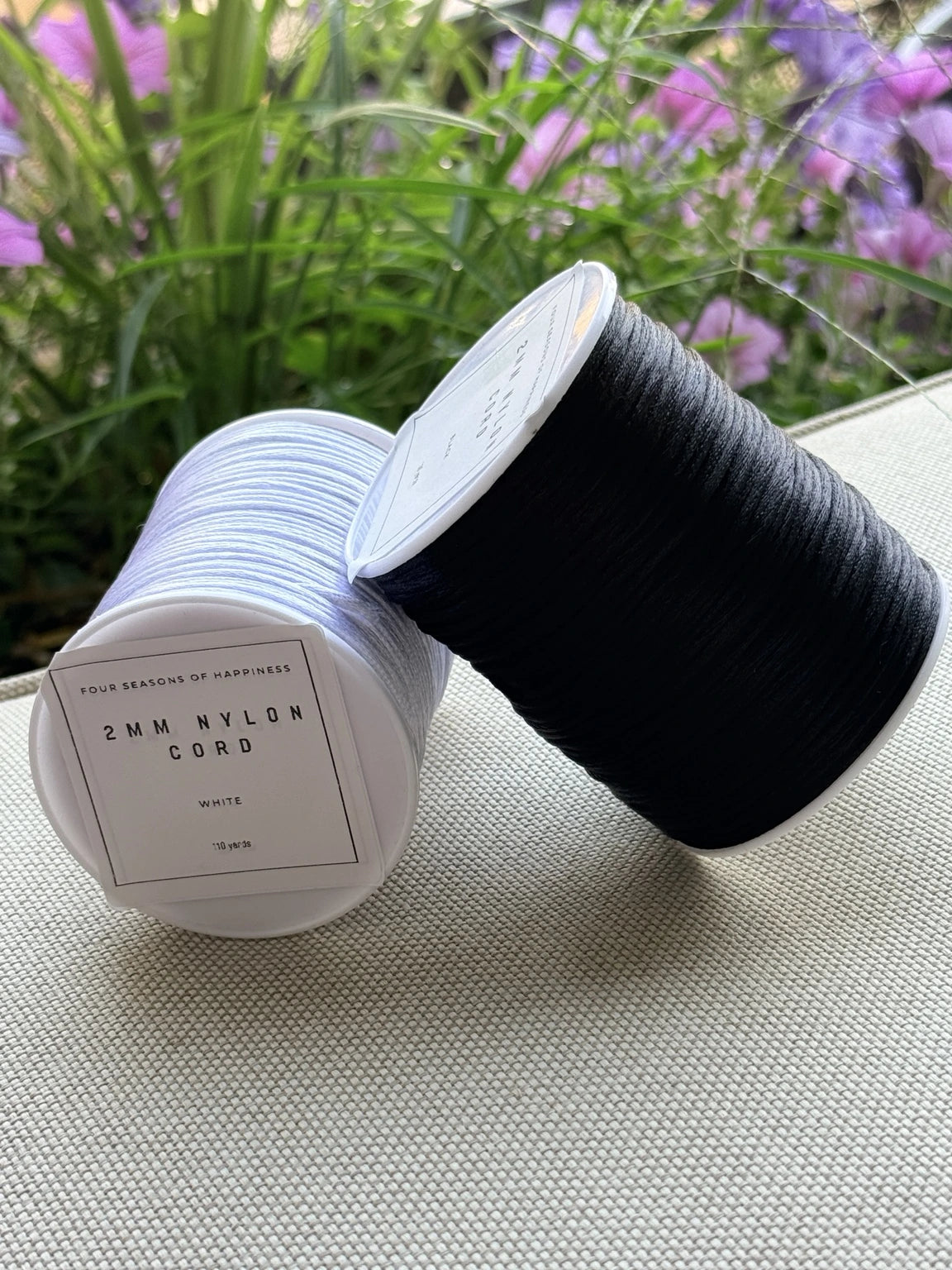 Black and white 2mm nylon cord spools from Four Seasons of Happiness, available in 110-yard spools for lanyards, keychains and craft projects.