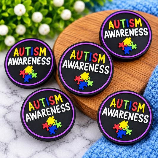 Round black Autism Awareness silicone focal bead with colorful lettering, purple border and multicolor puzzle-piece design from Four Seasons of Happiness.