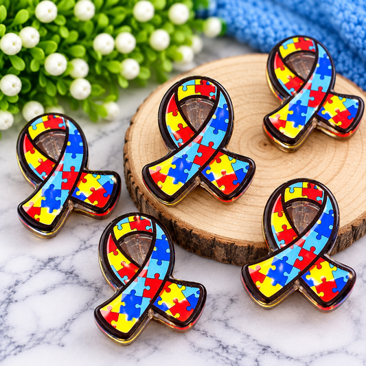 Colorful Autism Awareness puzzle ribbon acrylic focal bead with red, yellow and blue puzzle-piece design, sold individually by Four Seasons of Happiness.
