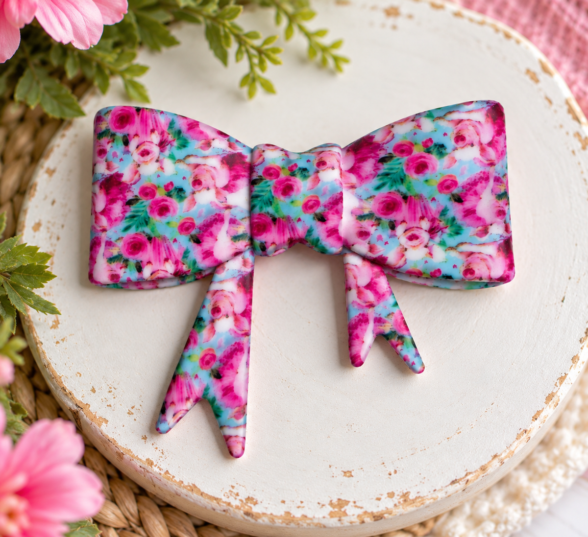Large silicone bow focal bead featuring vibrant pink watercolor flowers with aqua and green accents for DIY beading projects.