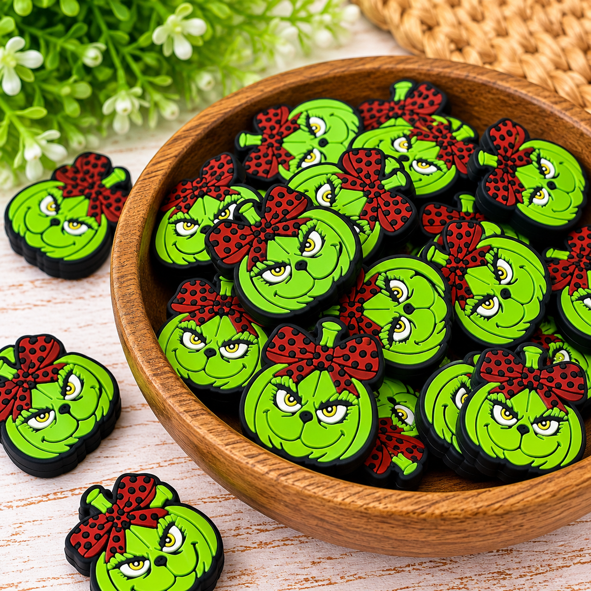 Whimsical green holiday silicone focal beads displayed in a decorative bowl for DIY wristlet keychains and bag charms