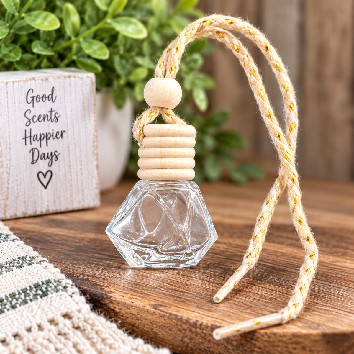 Clear glass hanging car diffuser bottle with natural wood cap and beige gold-accent cord, ready to fill for custom car freshener projects.