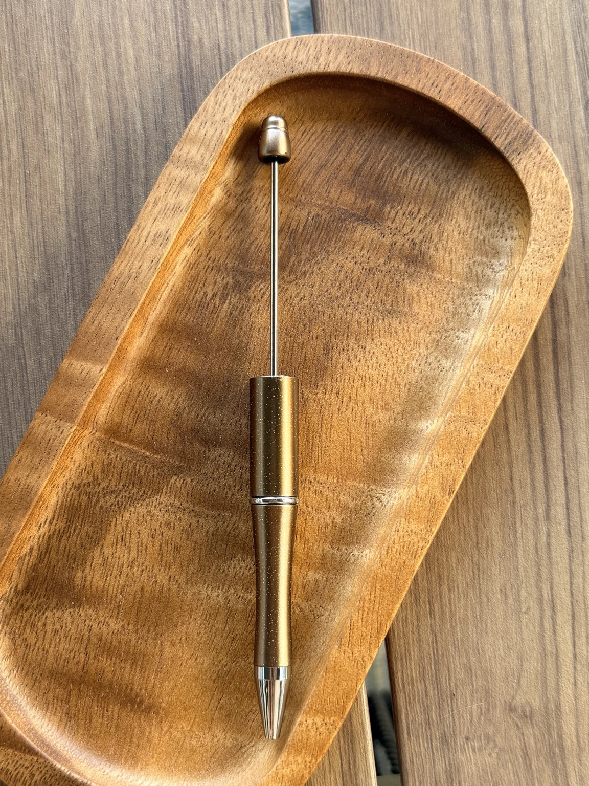 Bronze shimmer beadable pen featuring refillable black ink and a smooth medium ballpoint tip. Sold individually and designed for customization with silicone beads, focal beads, and spacer beads.
