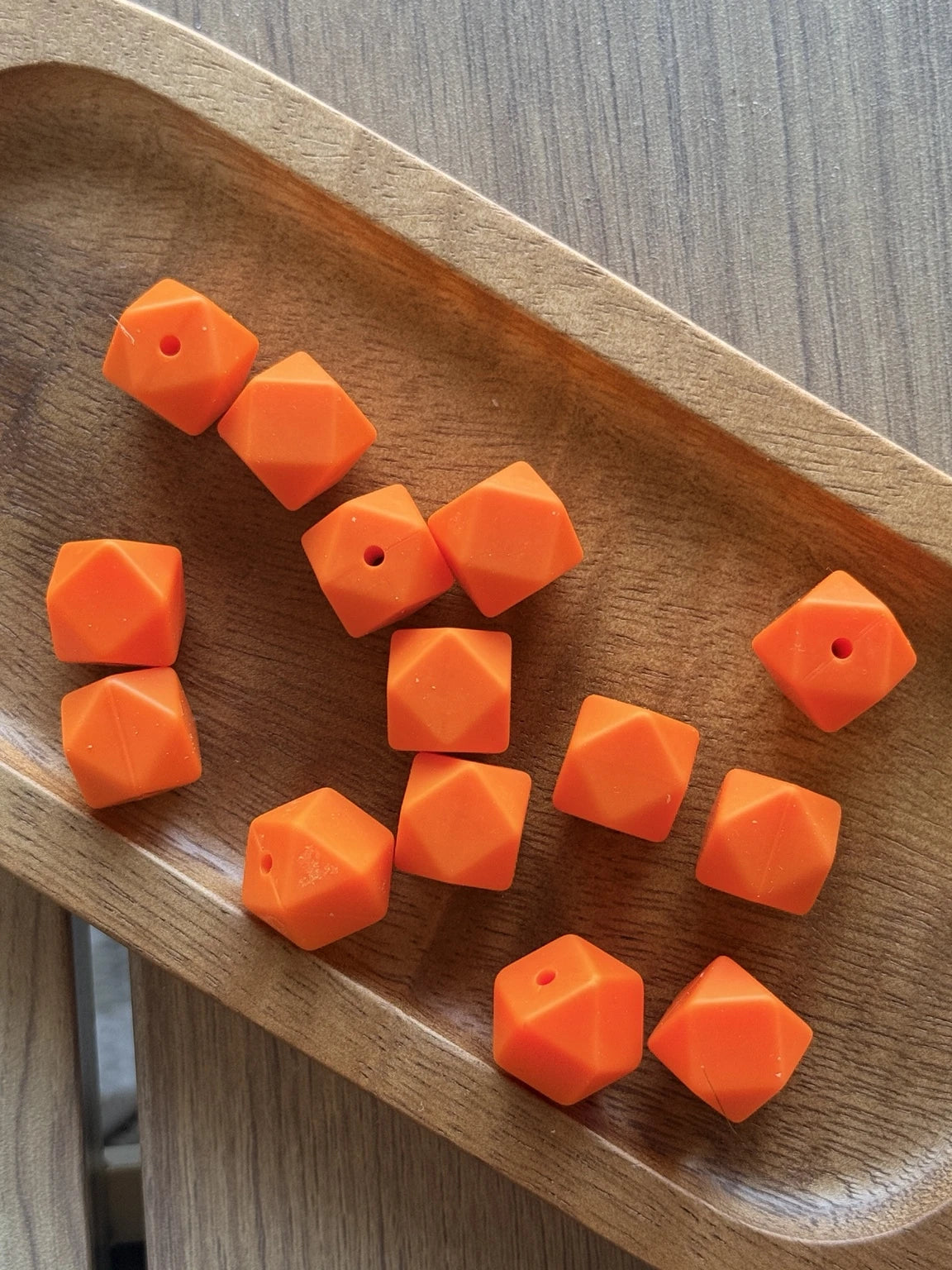 Bright orange 14mm silicone hexagon beads featuring a faceted geometric design. Available in 5-count and 10-count bags for beadable pens, keychains, wristlets, and DIY craft projects.