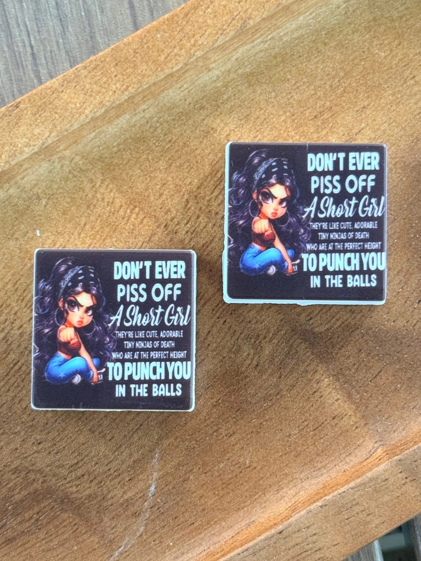Funny silicone focal bead featuring the phrase “Don’t Ever Piss Off A Short Girl” displayed on a wooden tray. Ideal for beadable pens, keychains, badge reels, wristlets, lanyards, and DIY crafting projects.