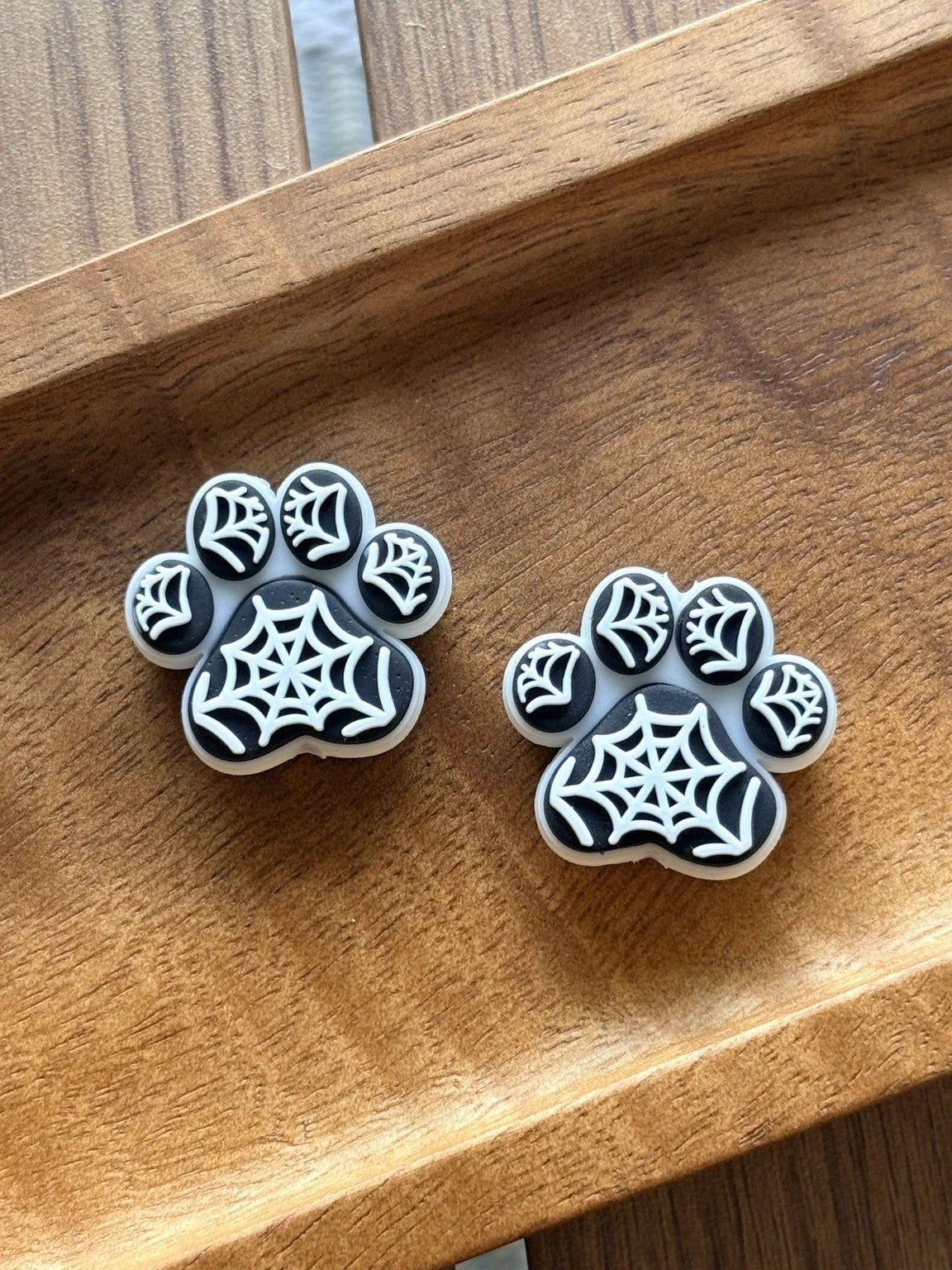 Black, white, and gray silicone focal bead featuring a paw print accented with spiderweb details. Perfect for Halloween beadable pens, keychains, wristlets, and pet-themed DIY crafts.