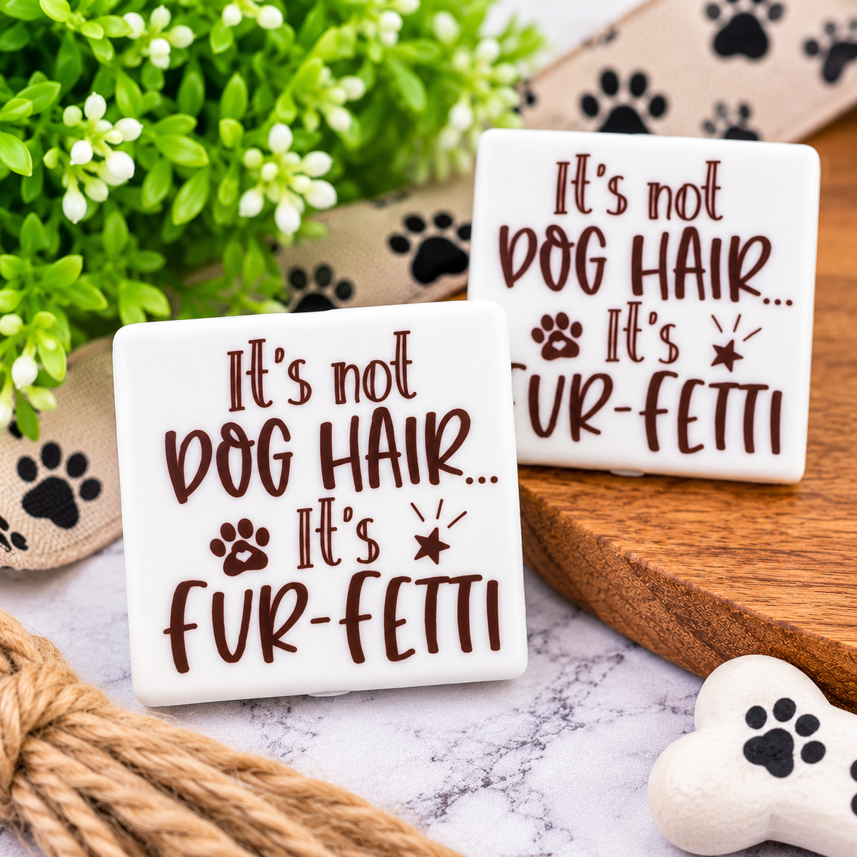 White silicone focal bead with brown “It’s not dog hair, it’s fur-fetti” lettering, paw print and star accents.