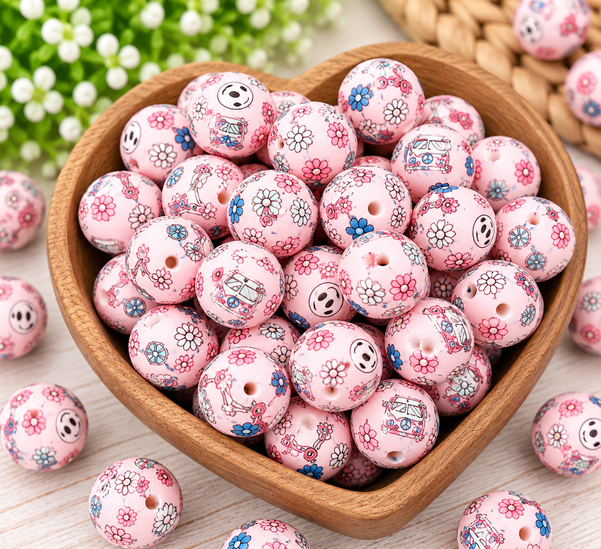 Happy Little Hippie 15mm printed silicone beads arranged in a wooden bowl, showcasing pastel pink beads with flowers, smiley faces, and retro-inspired designs for wristlet keychains.