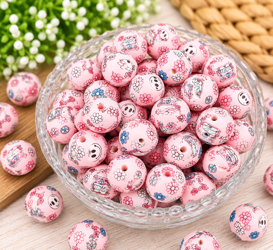 Pastel pink 15mm silicone beads featuring retro floral and smiley face prints displayed in a decorative glass bowl for DIY beading projects.