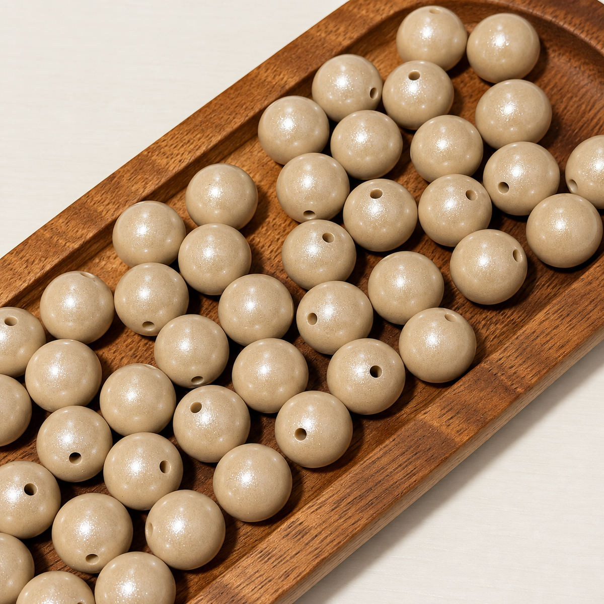 Ivory Glow 15mm round opal silicone beads with a warm ivory tone and subtle shimmer in a wooden tray. Sold individually.