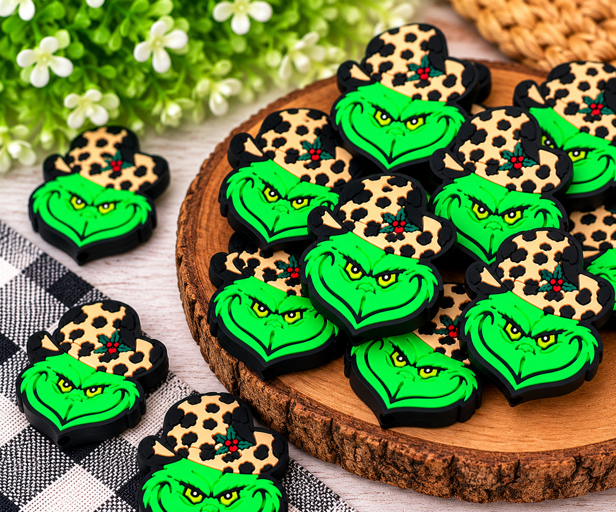 Bright green mischievous holiday silicone focal beads with yellow eyes and tan leopard-print hats displayed together