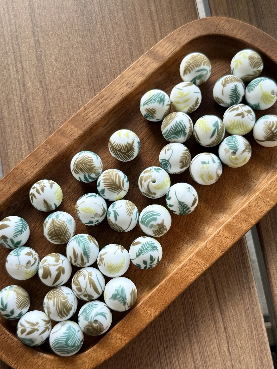 15mm printed silicone beads featuring tropical palm leaf patterns in sage green, mint, taupe, and olive tones on a white background, perfect for beadable pens, wristlets, keychains, badge reels, and DIY craft projects.