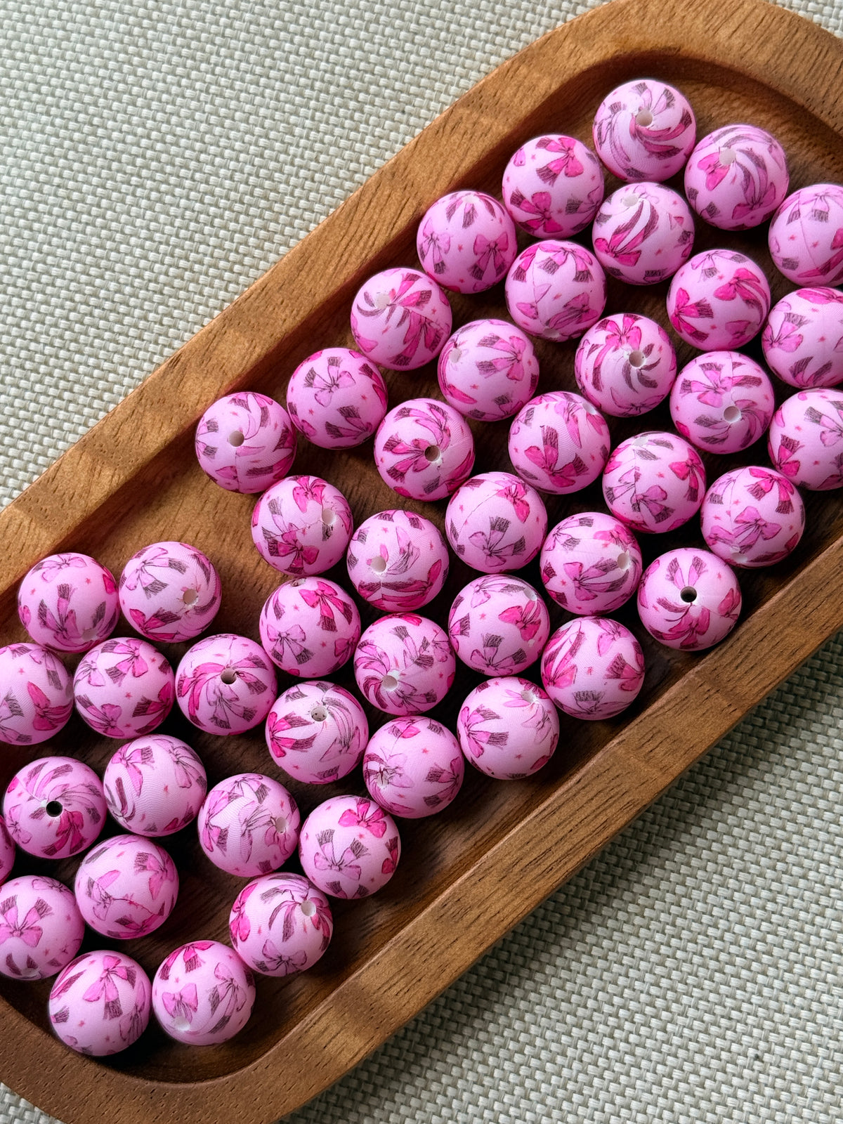 Pretty in Bows 15mm pink printed silicone round beads featuring assorted pink bow designs from Four Seasons of Happiness, sold individually for DIY crafts.