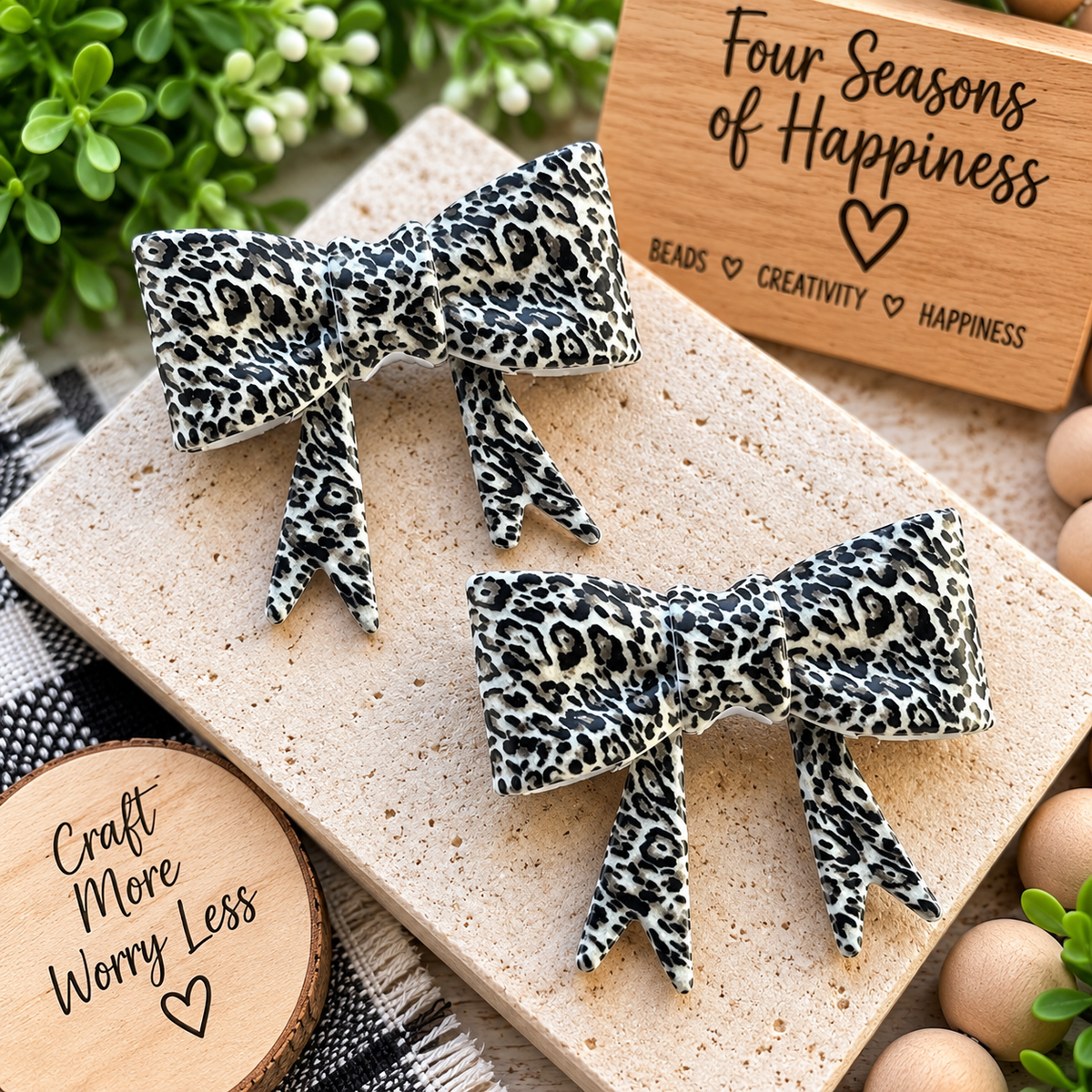 Wild Side Leopard large silicone bow focal bead featuring a black, charcoal and cream leopard print with long ribbon tails for car charms and keychains.
