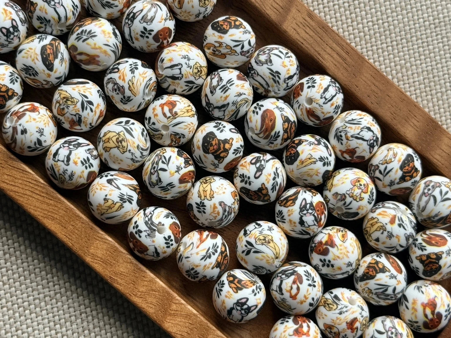 Autumn Paws 15mm printed silicone bead featuring assorted dogs with orange, brown, gold and dark botanical accents on a light background