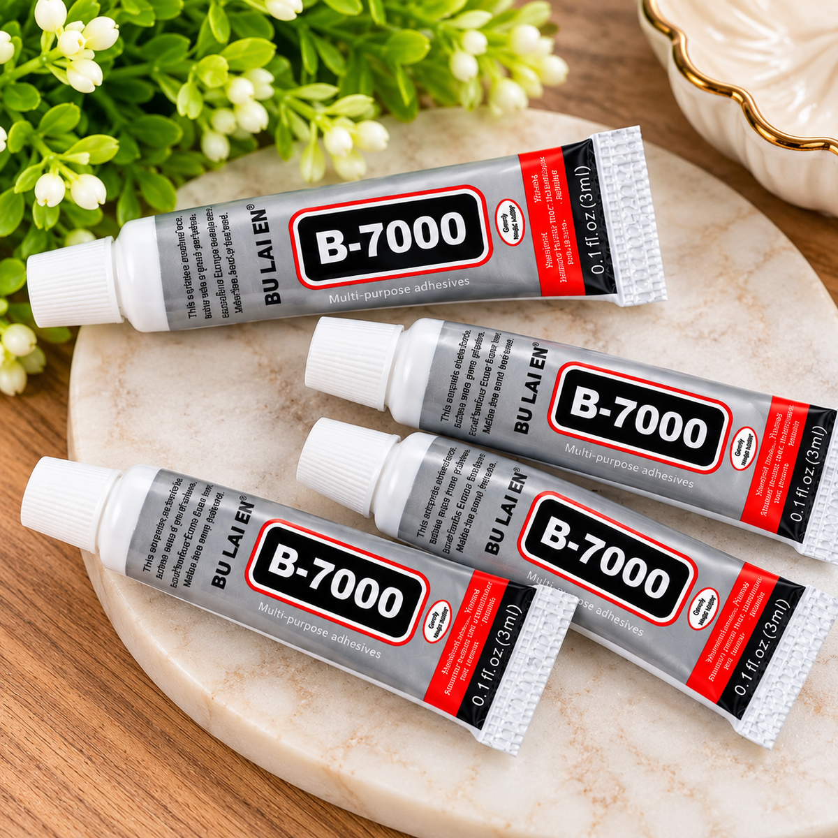B-7000 multi-purpose adhesive glue in a 3ml silver squeeze tube with white cap, ideal for rhinestone embellishments, jewelry making, keychain crafts, and DIY projects.
