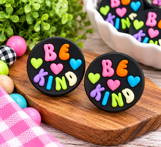 Black round Be Kind silicone focal bead featuring colorful raised letters and bright hearts in pink, orange, blue, purple, lime green, and cream, perfect for DIY wristlets and keychains.
