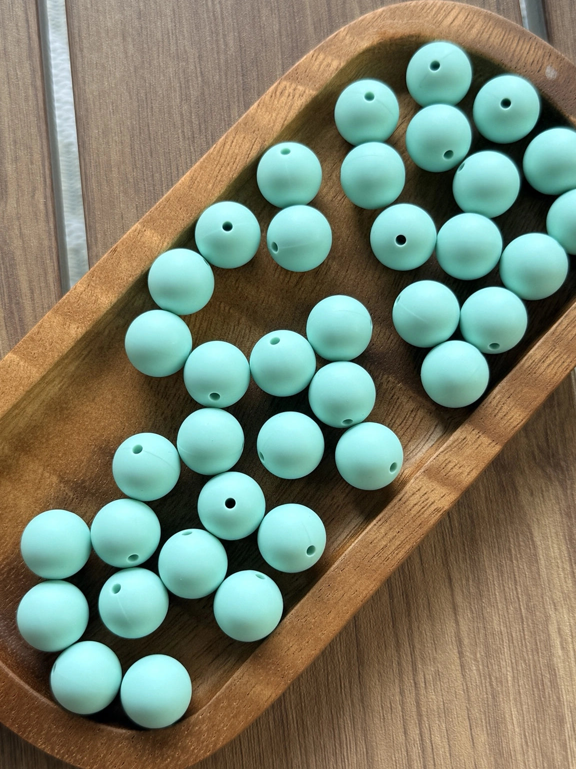 Coastal Mint 15mm matte silicone round beads displayed in a wooden tray for DIY crafts, beadable pens, jewelry making, wristlets, badge reels, and keychain accessories.
