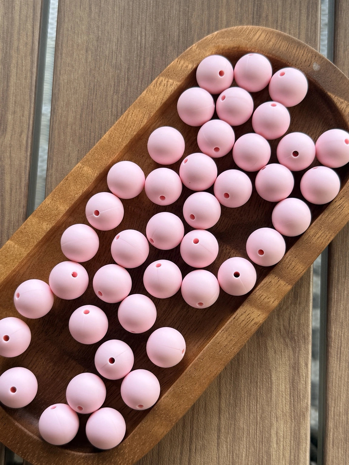Soft pastel pink 15mm matte silicone round beads displayed on a wooden tray for beadable pens, jewelry making, wristlets, and DIY craft projects by Four Seasons of Happiness