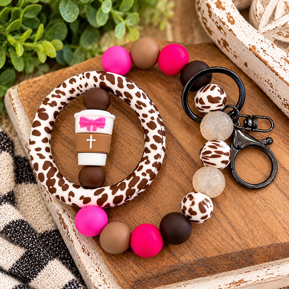Faith and Bows Coffee Cup silicone bead wristlet featuring a 65mm Brown Country Cowhide printed ring, coordinating cowhide beads, pink and brown matte silicone beads, glitter jelly accents, and lobster claw keychain.