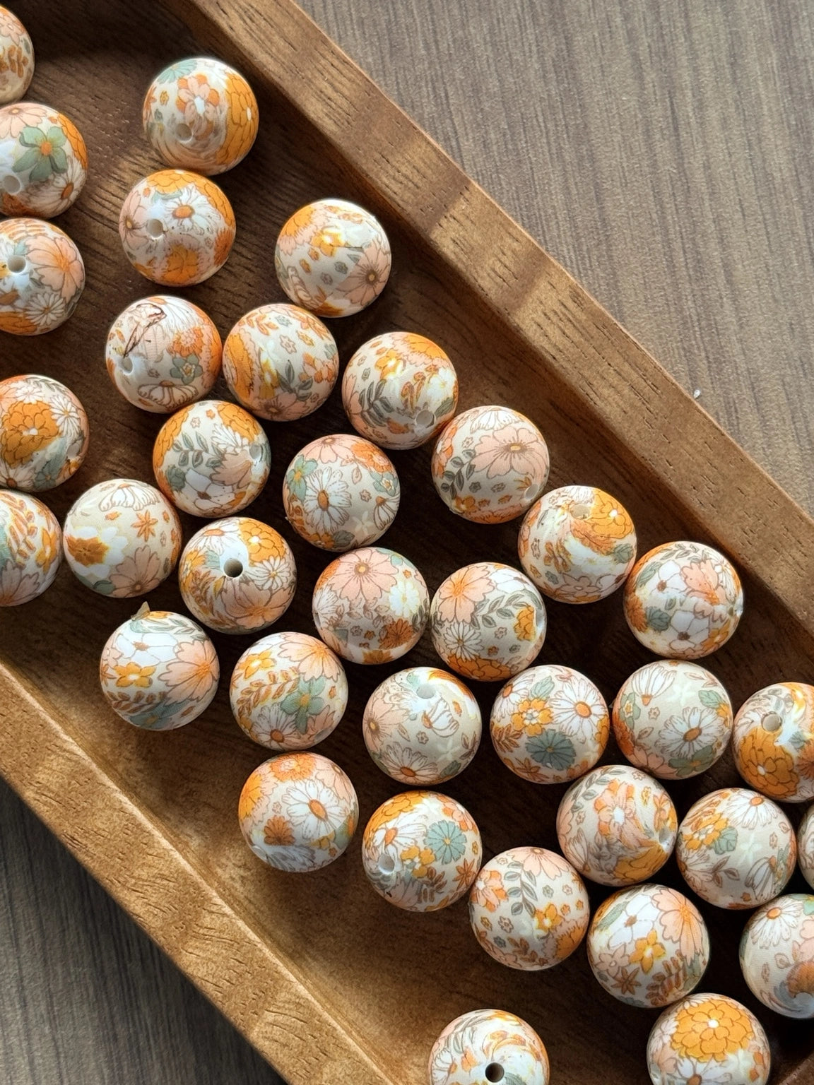 Autumn Bloom 15mm printed silicone beads featuring warm orange, peach, cream, muted green and soft blue vintage floral designs for handmade crafts.