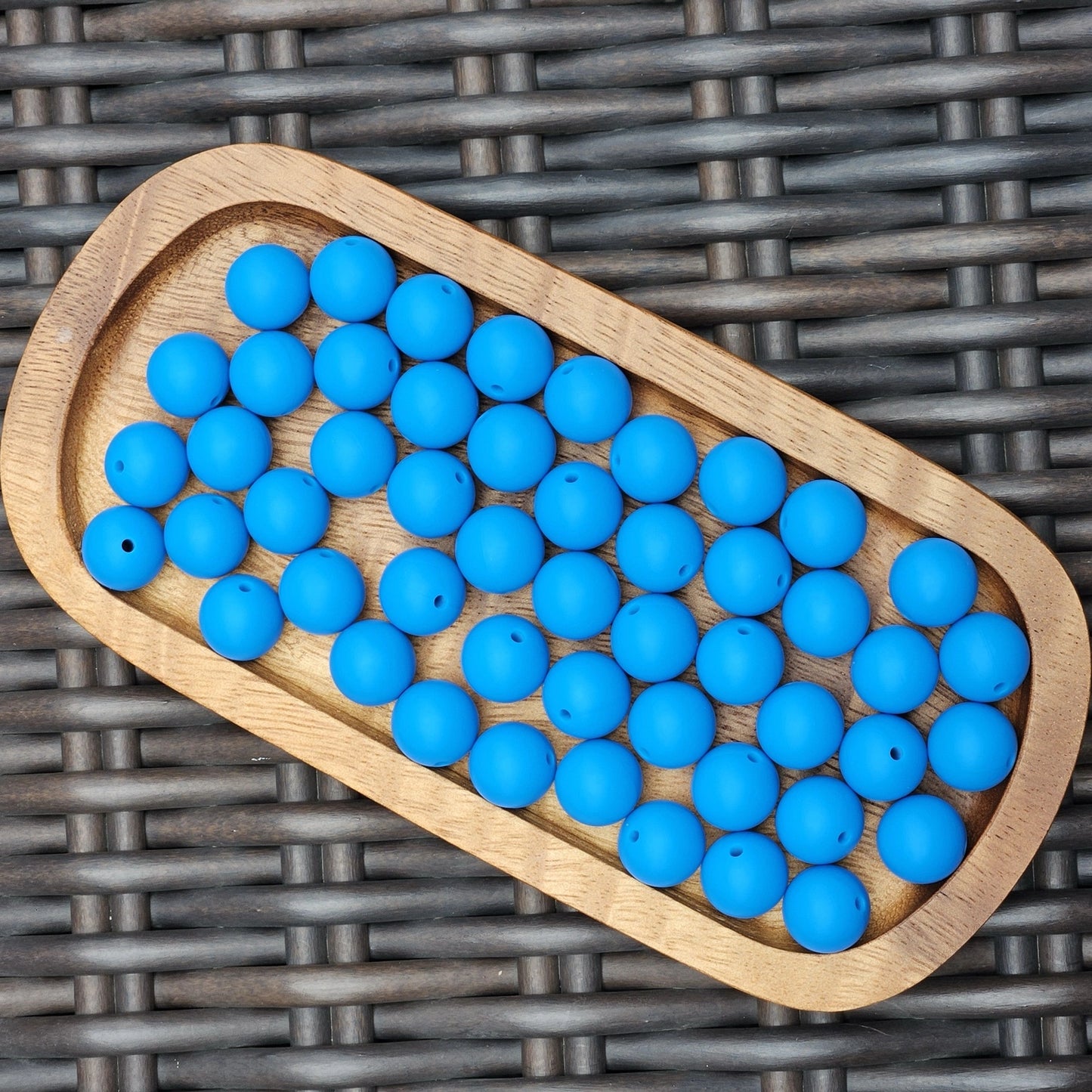 Blue Horizon 15mm solid matte silicone beads in a vibrant blue shade displayed in a wooden tray. Premium BPA-free craft beads for beadable pens, wristlets, keychains, badge reels, jewelry, and DIY handmade projects.