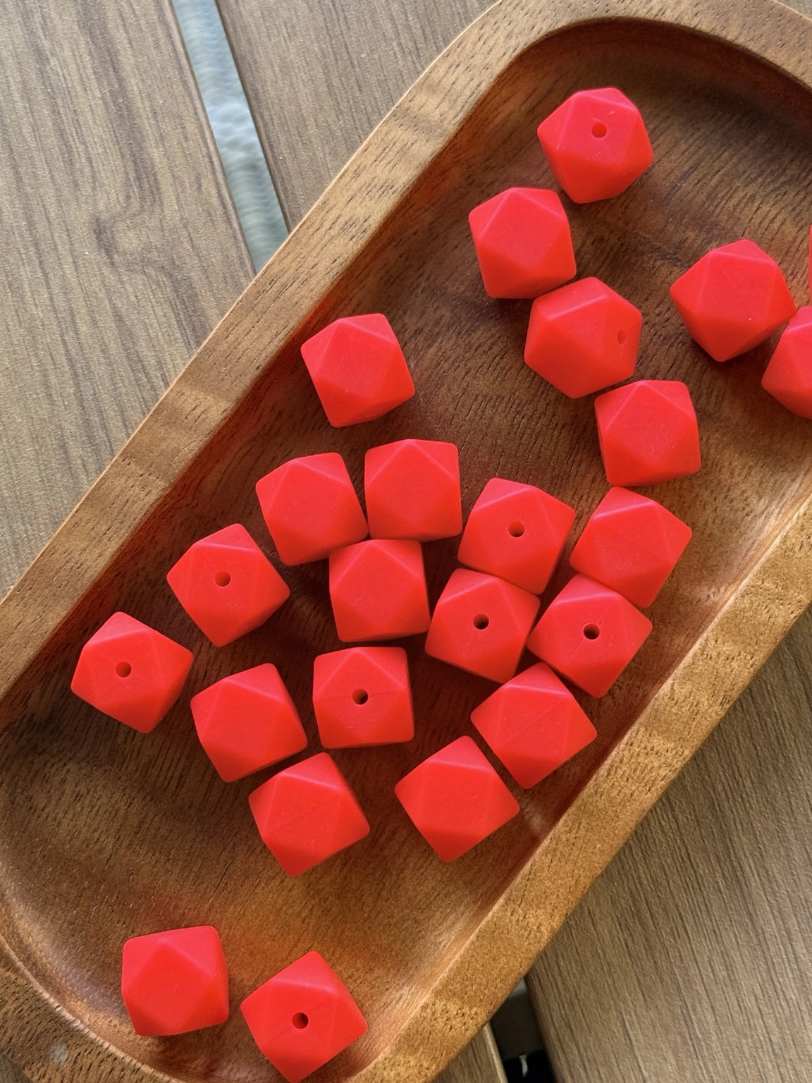 Bright red Cherry Pop 14mm silicone hexagon beads displayed on a wooden tray for beadable pens, keychains, wristlets, badge reels, lanyards, and DIY craft projects.