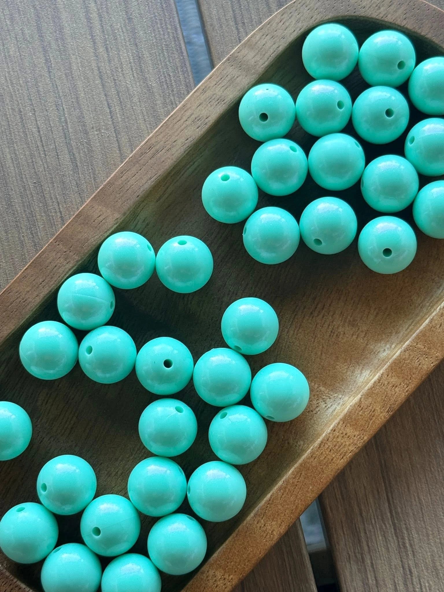 Coastal Mint Opal 15mm silicone bead with a pearlescent mint aqua finish displayed in a wooden tray. Premium BPA-free craft bead sold individually for beadable pens, keychains, wristlets, badge reels, jewelry making, and DIY craft projects.