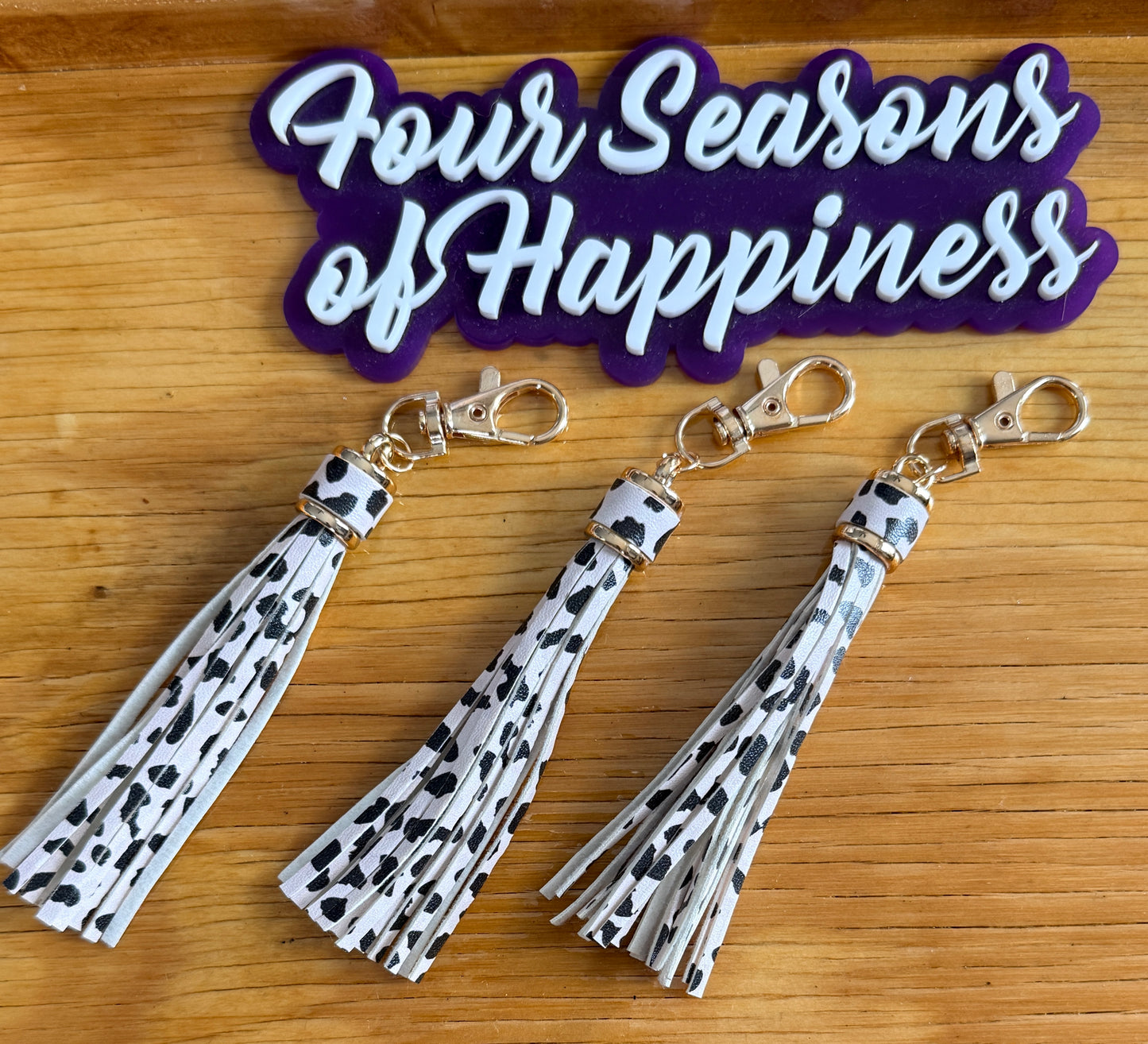 Cow print faux leather tassel keychain charm from Four Seasons of Happiness with gold hardware for keychains, bags, and DIY craft projects