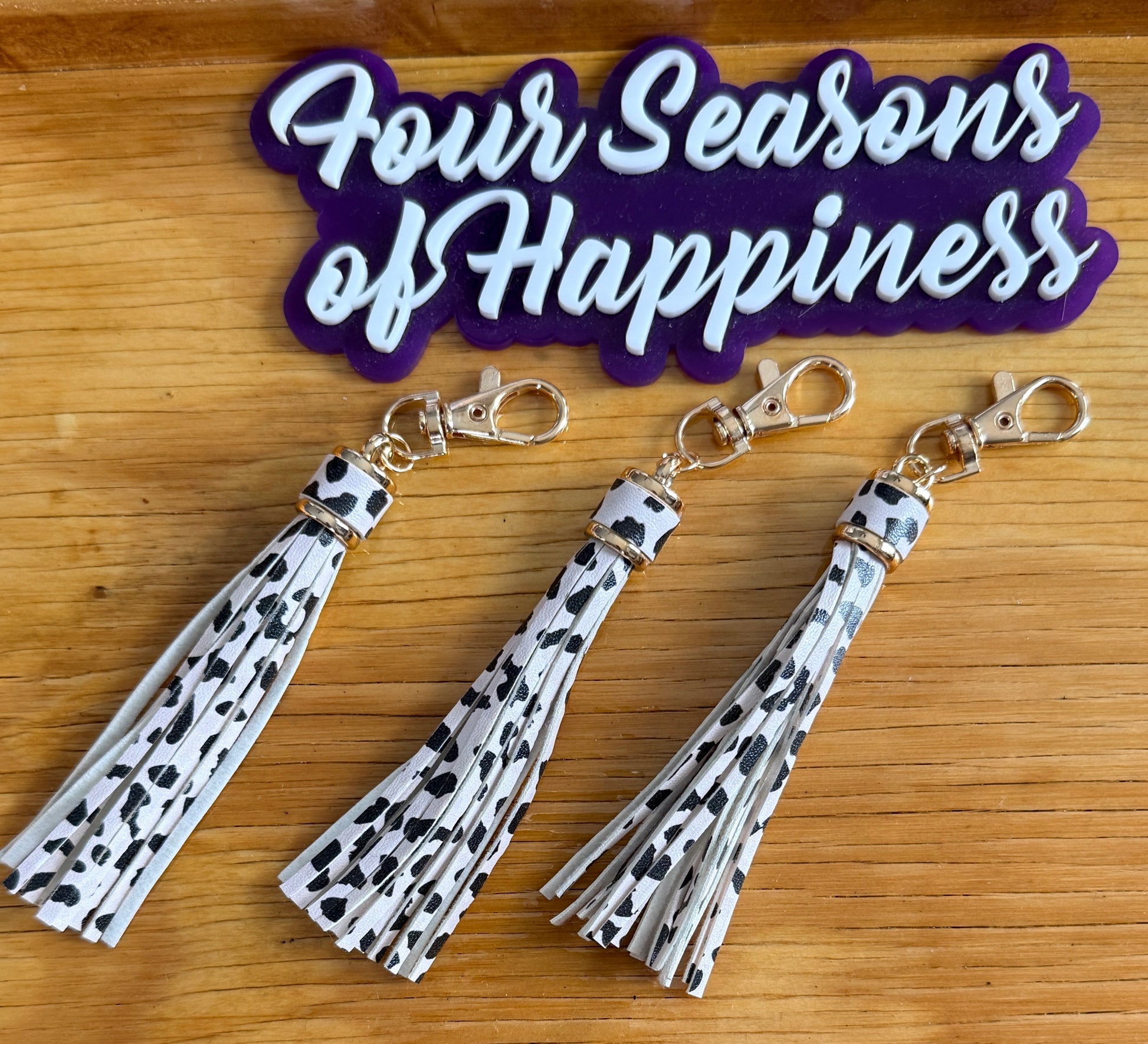 Cow print faux leather tassel keychain charm from Four Seasons of Happiness with gold hardware for keychains, bags, and DIY craft projects