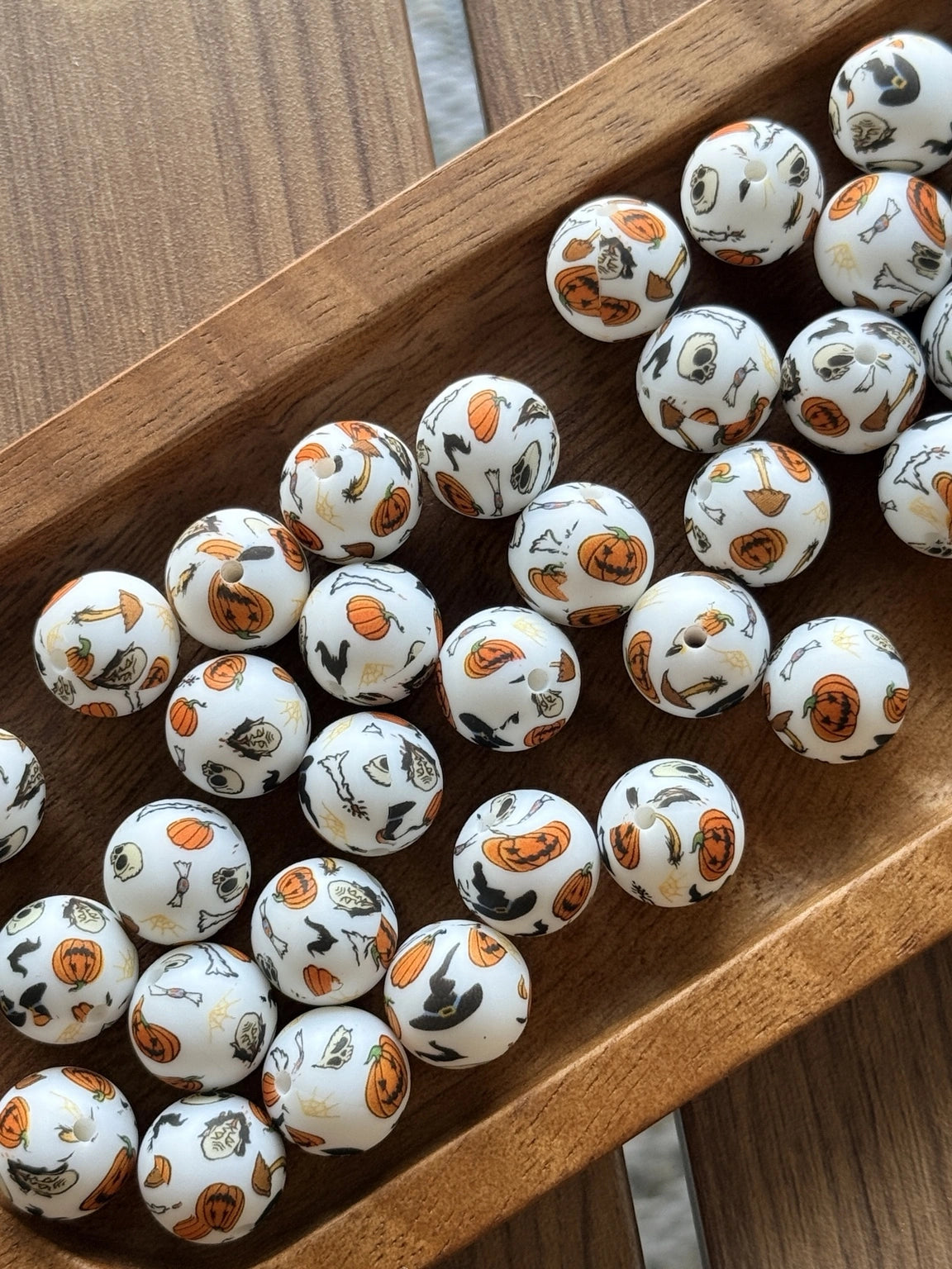 White 15mm silicone printed bead featuring pumpkins, ghosts, bats, candy, skulls, brooms, and Halloween icons for seasonal keychains, wristlets, pens, and DIY craft projects.