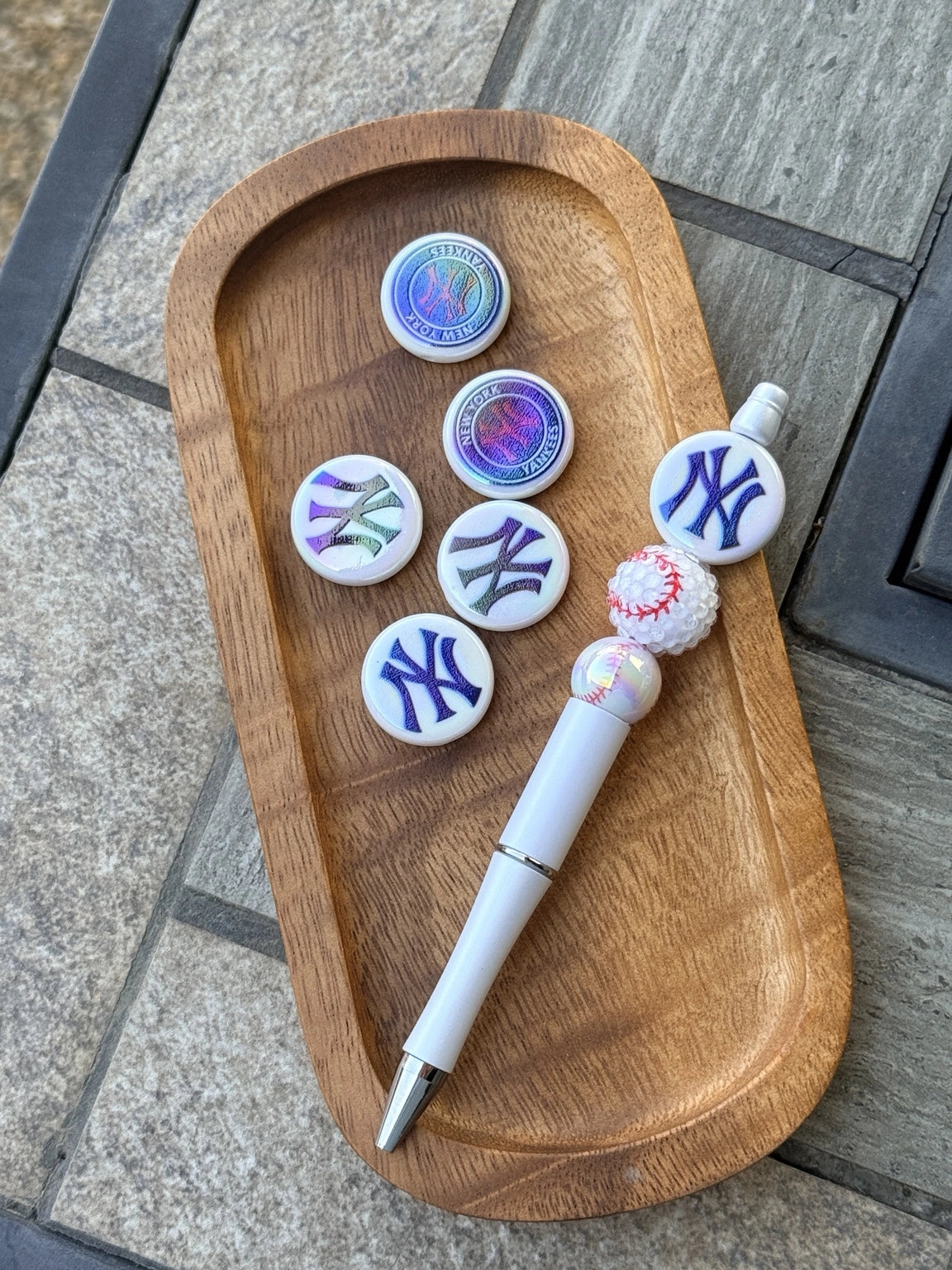 iridescent baseball themed acrylic focal beads displayed with beadable pen on wooden tray