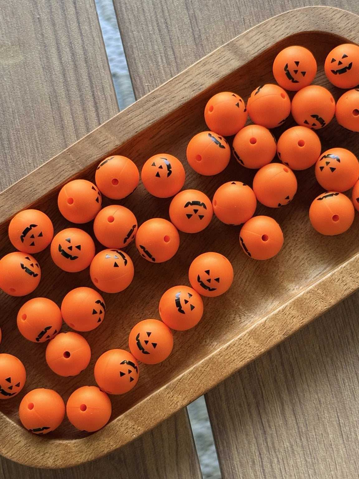 Orange 15mm silicone printed bead featuring a black jack-o'-lantern pumpkin face design for Halloween keychains, wristlets, pens, and DIY craft projects.