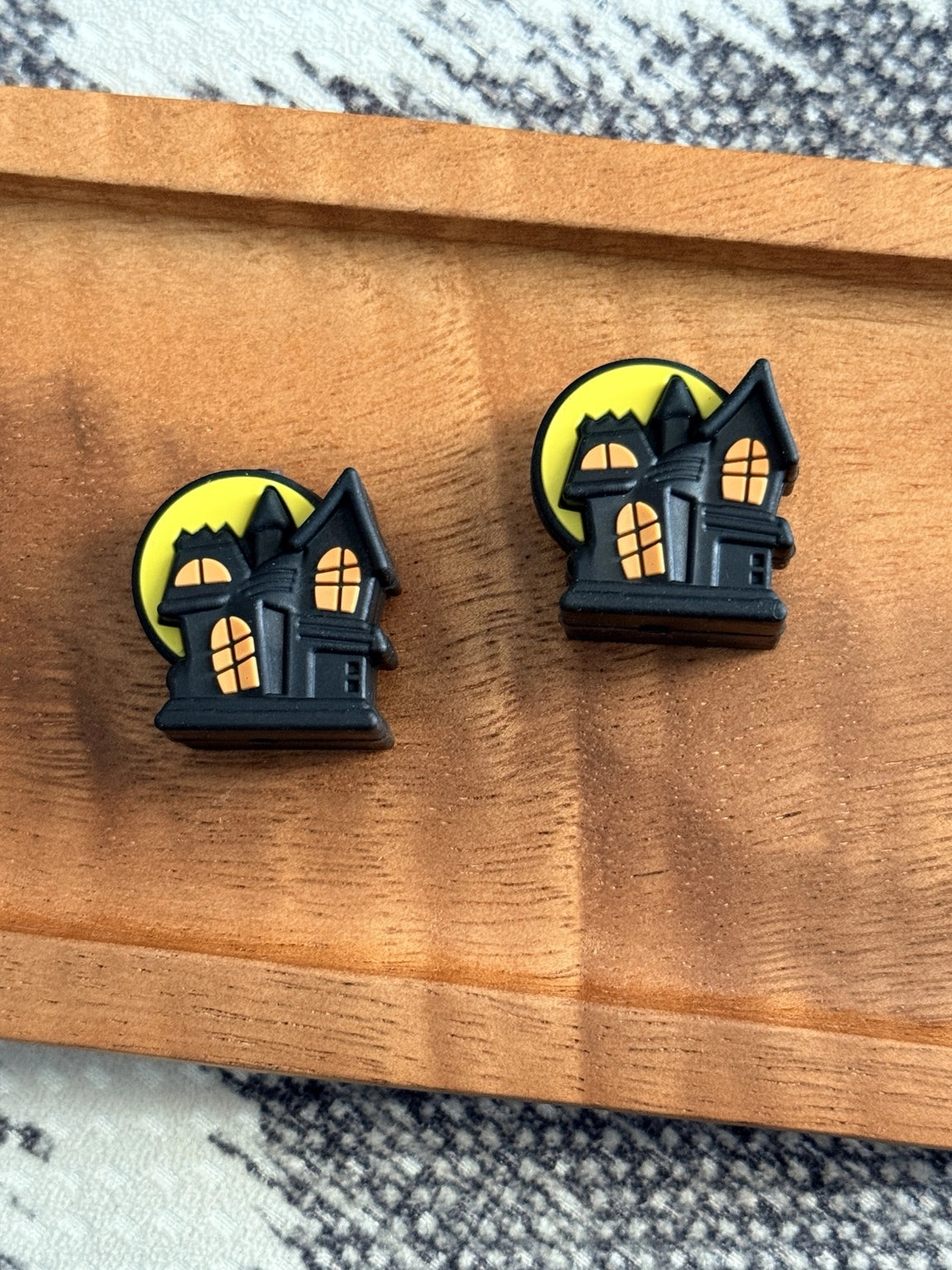 Black haunted house silicone focal bead with glowing orange windows and a yellow full moon for Halloween pens, keychains, wristlets and DIY crafts.