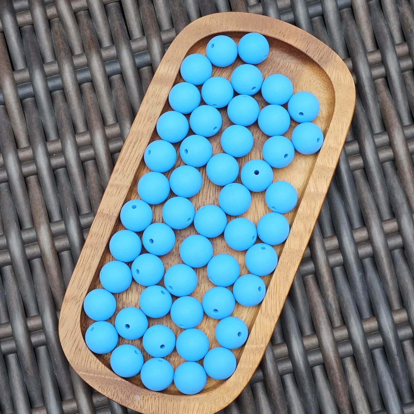 Ocean Current 15mm solid matte tropical blue silicone beads displayed in a wooden tray. Premium BPA-free craft beads for beadable pens, wristlets, keychains, badge reels, jewelry, and DIY handmade projects.
