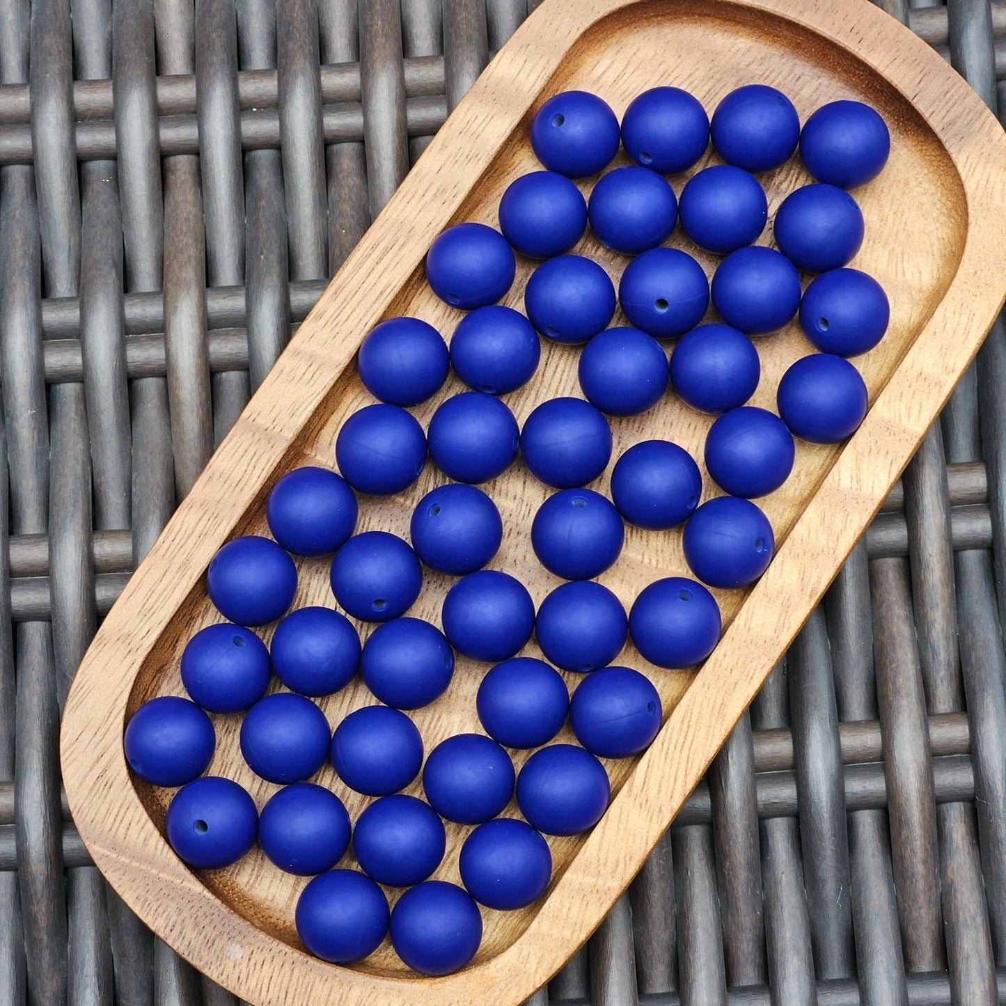Sapphire Tide 15mm solid matte silicone beads in a vibrant royal blue color displayed in a wooden tray. Premium BPA-free craft beads for beadable pens, keychains, wristlets, badge reels, jewelry making, and DIY craft projects.