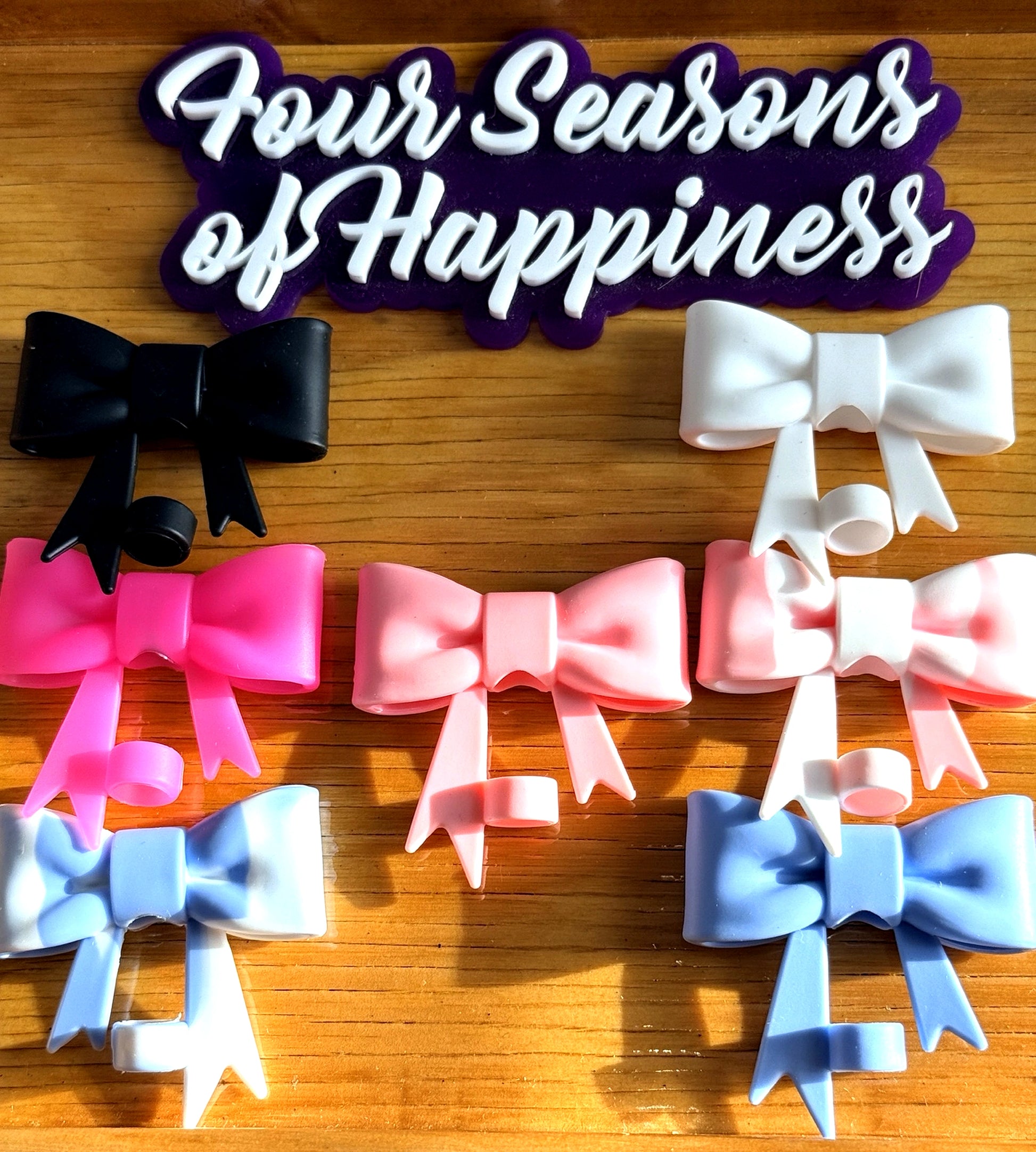 Silicone bow straw charms from Four Seasons of Happiness for decorating drink cups in pink, blue, black and white colors