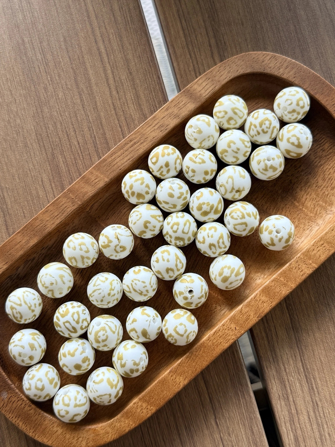 Golden Snow Leopard 15mm printed silicone bead featuring a white background with gold leopard print accents for beadable pens, keychains, wristlets, jewelry making, and DIY crafts. 