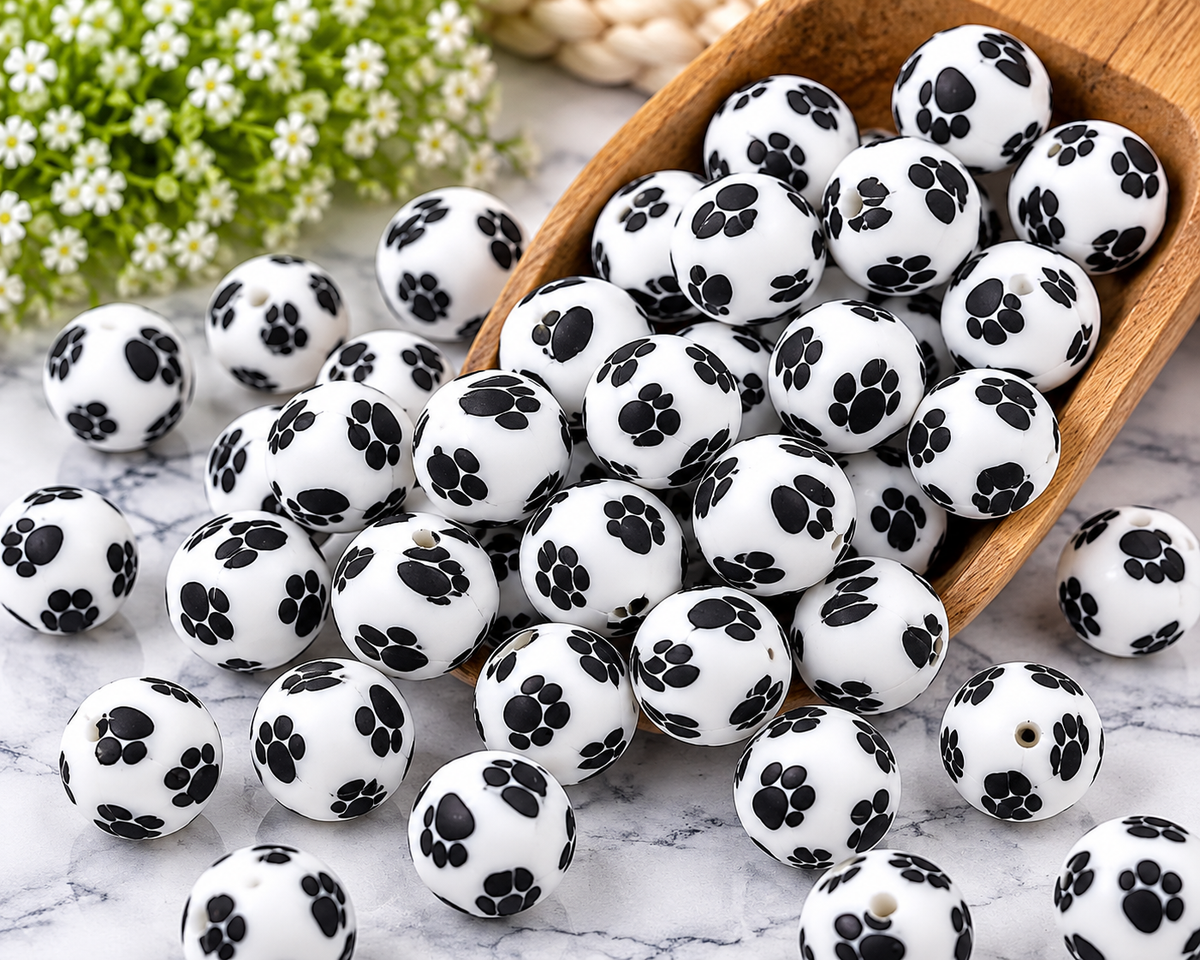 Happy Paws 15mm printed silicone beads featuring black paw prints on white round beads for wristlet keychains and DIY crafts.