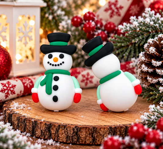Mr. Merry Snowflake Christmas snowman silicone focal bead featuring a smiling white snowman with a black top hat, green scarf, red mittens, orange carrot nose, and black buttons, sold individually.