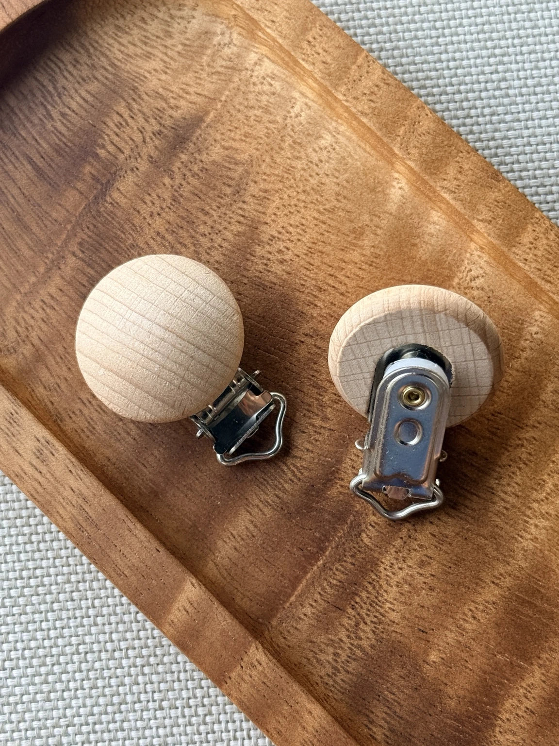 Natural unfinished wood pacifier clips with silver metal clip hardware for creating DIY beaded pacifier holders and handmade baby accessories.