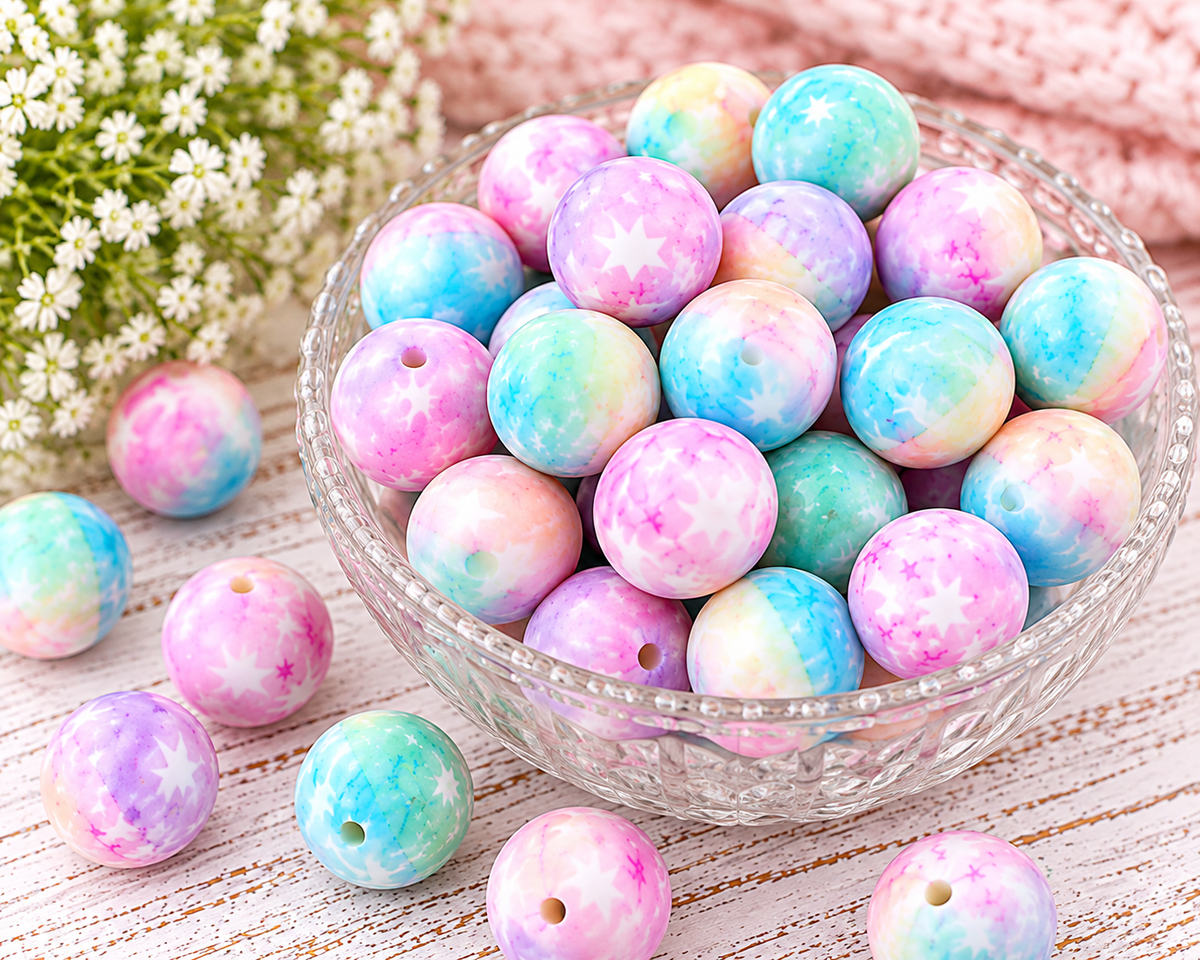 Close-up of Starlight Wishes 15mm round silicone beads with pastel watercolor colors and scattered star prints.