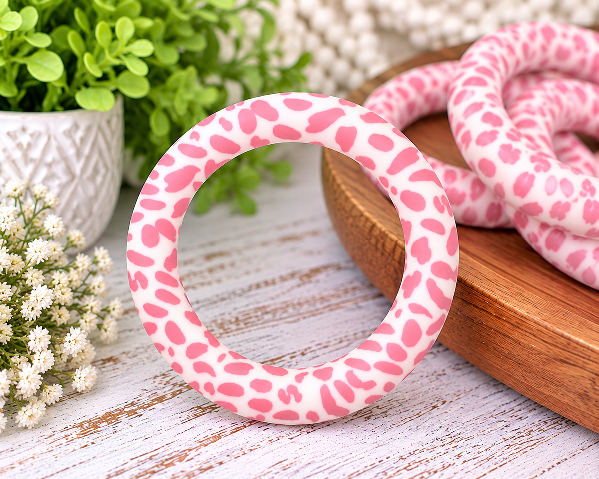 Pink cow print 65mm silicone ring bead with a creamy white background and irregular pink spots for wristlet keychains and DIY crafts.