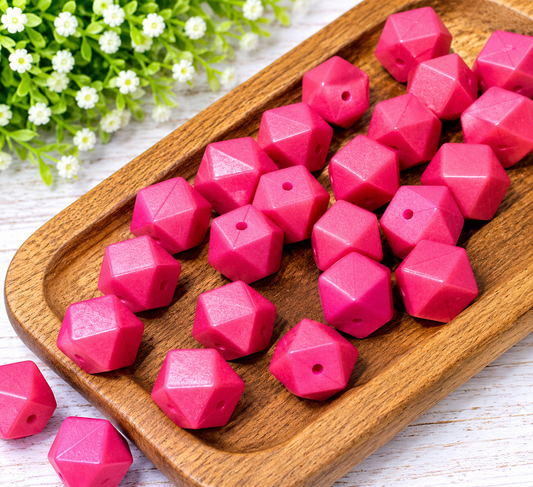 Vibrant pink 14mm silicone hexagon beads with faceted geometric shapes displayed in a wooden tray