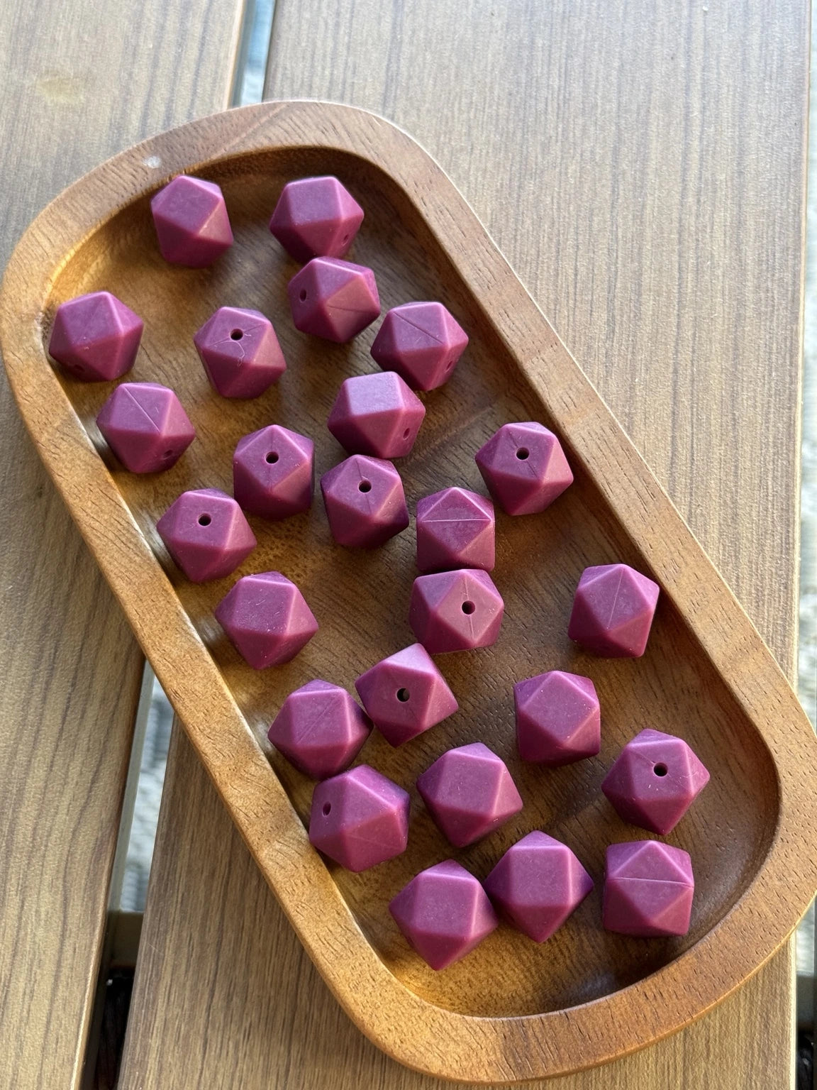 Plum Passion 14mm matte silicone hexagon beads displayed in a wooden tray. Premium food-grade silicone beads available in 5-count and 10-count bags from Four Seasons of Happiness for keychains, pens, badge reels, wristlets, and DIY crafts.